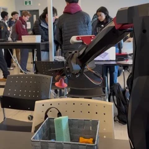 Q-Arm robot using the custom gripper to place an object into a bin